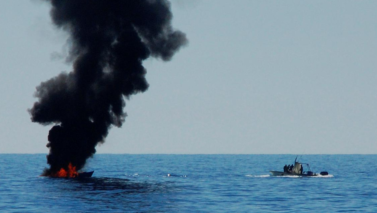 Een migrantenboot is in brand gestoken door de Libische kustwacht nadat de opvarenden zijn gered door ngo-schepen 20 mijl uit de kust van West-Libië, 18 mei. Beeld reuters