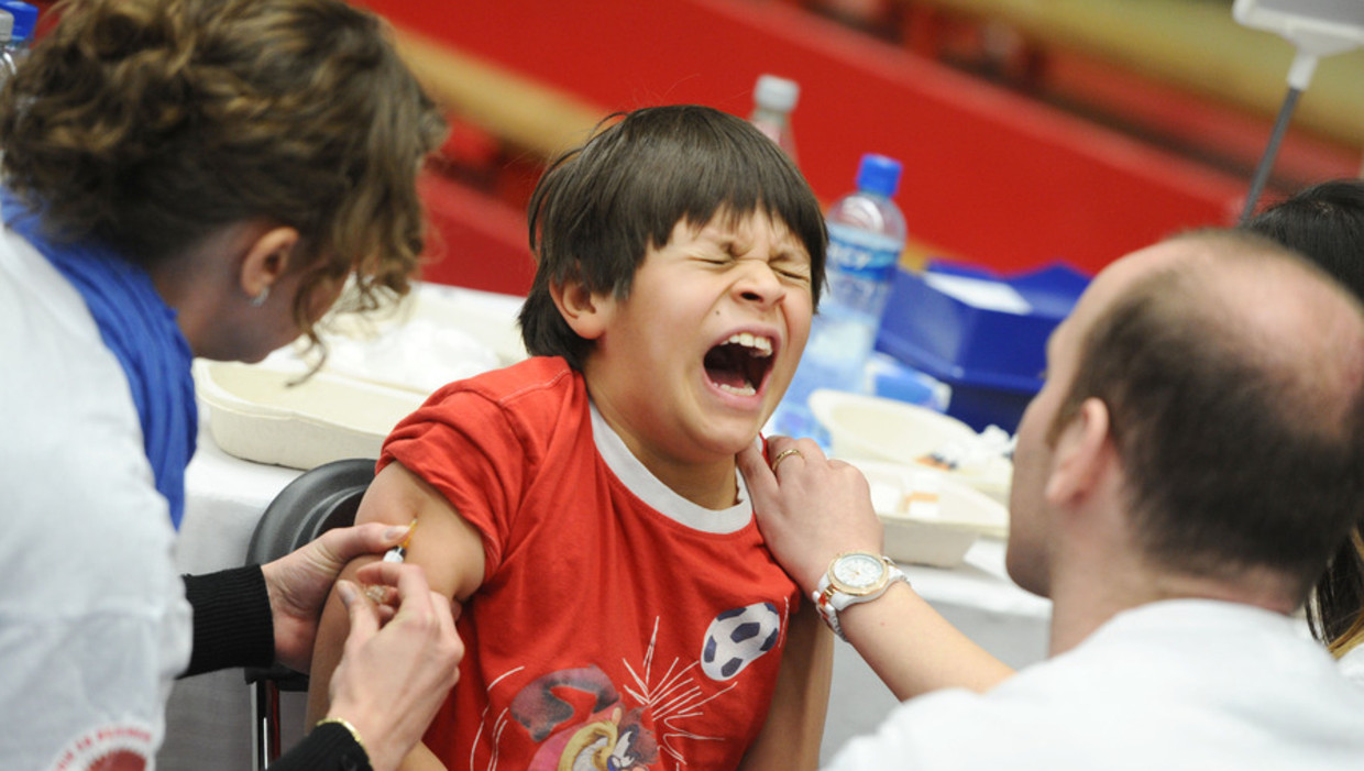 Een kind schreeuwt het uit tijdens een grote vaccinatie-actie in Sporthallen-Zuid in Amsterdam. Beeld anp