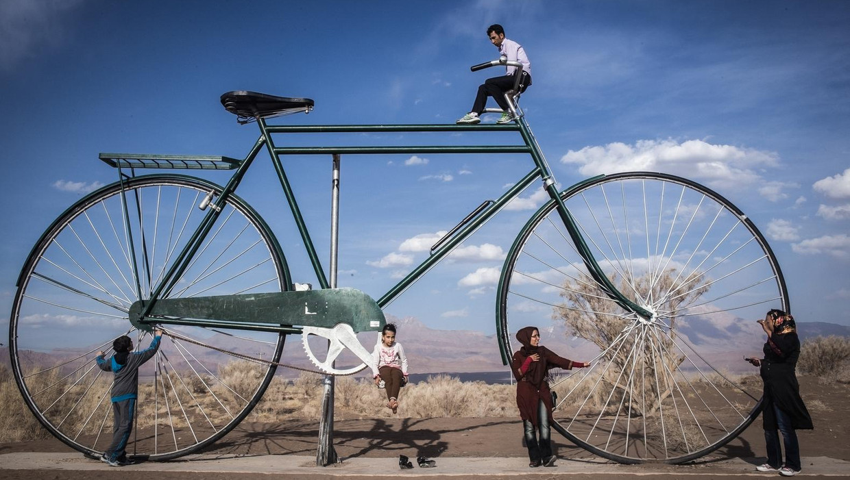Iraniërs bij een reuzenfiets in Kerman. Uit de serie 'Duizend-en-één Irans'die fotograaf Nicola Zolin maakte van alledaagse taferelen aan de vooravond van de verkiezingen Beeld Nicola Zolin