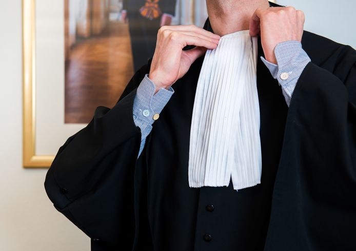 Een rechter schikt het befje om zijn toga.