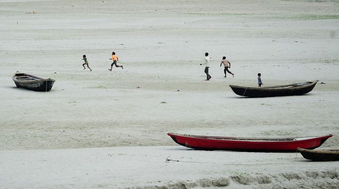 Nu al een feit: de droge rivierbedding van de Ganges, waar kinderen achter een vlieger aanhollen.