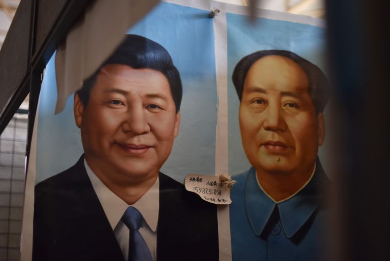 ► Een portret van Xi Jinping naast dat van Mao Zedong. Xi lijkt af te stevenen op een bijna keizerlijke status als Mao. Beeld AFP