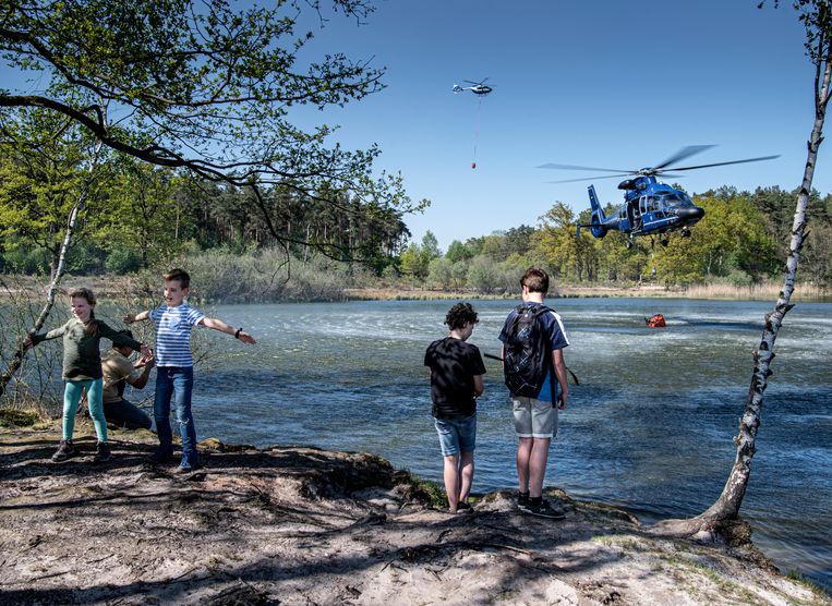 Een helikopter uit Duitsland haalt water bij een ven in de buurt van de grote brand. Beeld Koen Verheijden