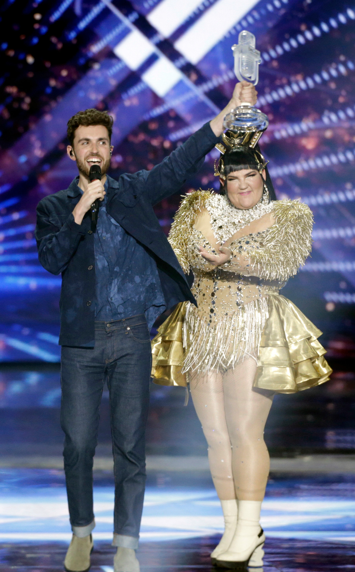 Duncan Laurence krijgt de trofee uit handen van Netta, de Israëlische winnares van vorig jaar.  Beeld EPA