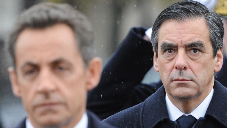 De Franse president Nicolas Sarkozy met de ex-premier Francois Fillon op de achtergrond. Beeld AFP