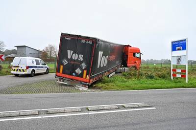 Vrachtwagen belandt na scherpe draai met trailer in sloot bij Heukelom