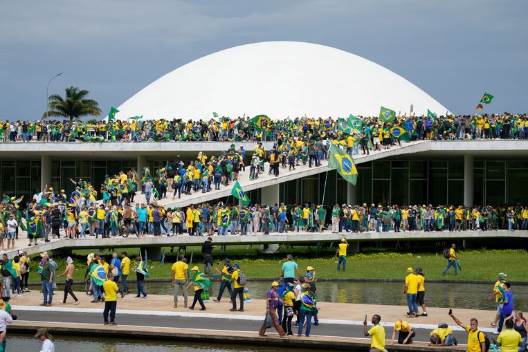 Aanhangers van oud-president Bolsonaro eerder zondagmiddag op en voor het parlement. Beeld AP