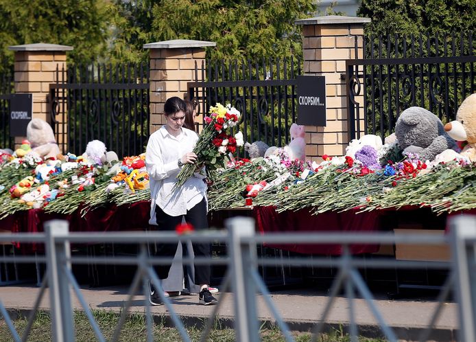 Molte persone vengono a deporre fiori e giocattoli nel santuario delle vittime all'ingresso della scuola.