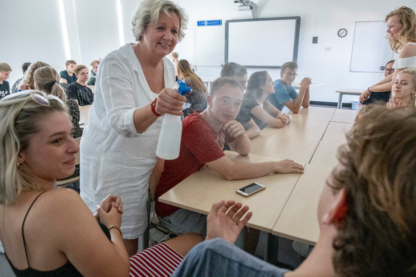 Docente Corina Schoonen houdt leerlingen van het Nehalennia in Middelburg koel met een plantenspuit.