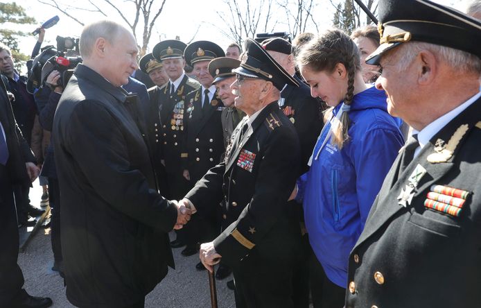 Russisch president Vladimir Poetin schudt de hand van Russische marineveteranen op de Krim. Hij reisde vandaag naar het schiereiland om de vijfde verjaardag van de  annexatie te vieren.