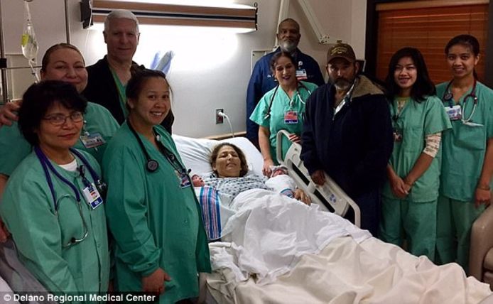 Maria met de tweeling en haar man omringd door medisch personeel van het Delano Regional Medical Center.