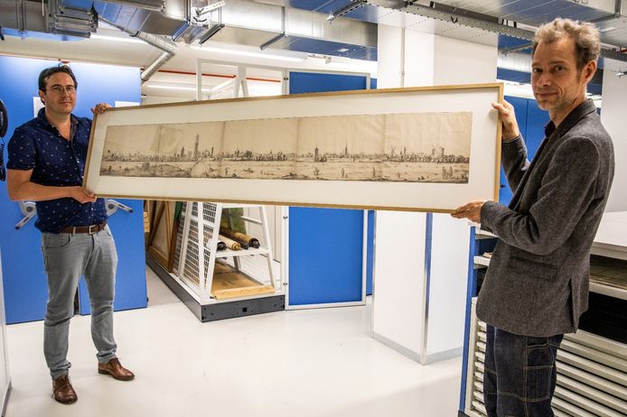 Alexander Roos (links) en Victor Lansink (rechts) houden een panoramaschilderij uit 1669 vast. Het kijkt uit op Utrecht. Dit archiefstuk is normaal niet te zien voor het publiek.