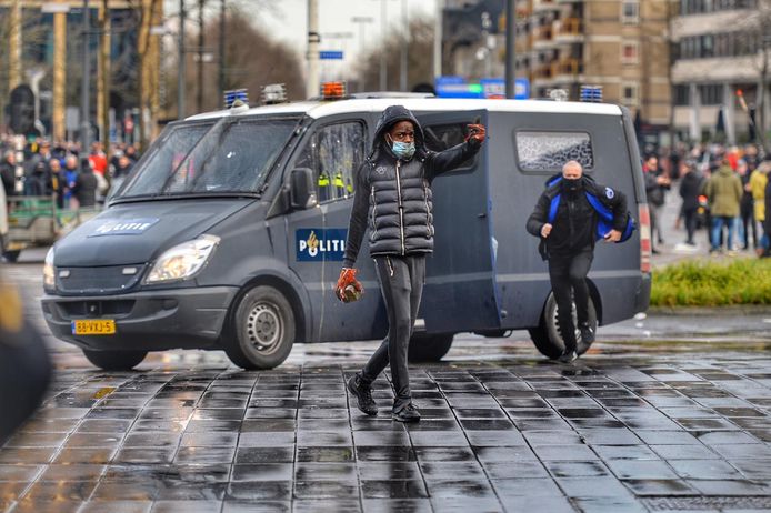 Relschoppers gooien stenen naar de politie.