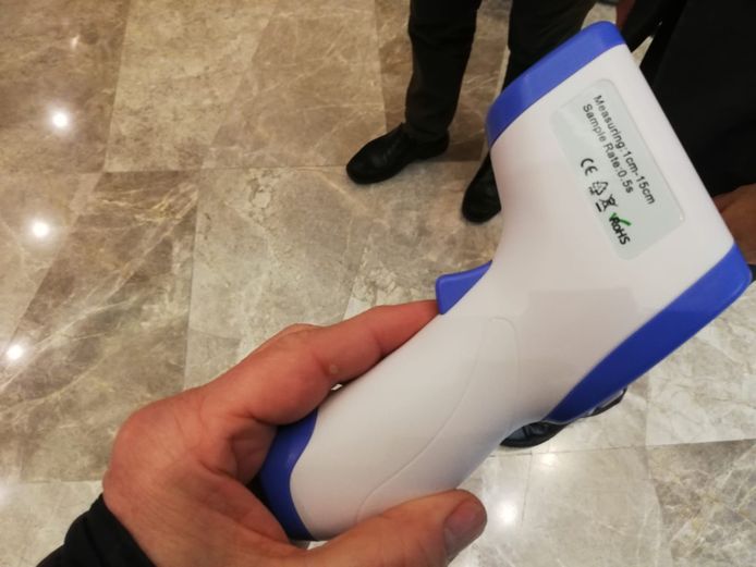 Iedere bezoeker van China krijgt zo'n thermometer op zijn voorhoofd gezet. Te hoge temperatuur? Naar het gezondheidscentrum.