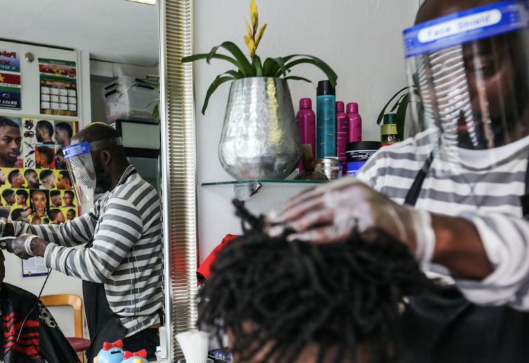 Buurtwerker Taiwo Feyisipo knipt voor een lage prijs het haar van de buurtbewoners. Beeld Eva Plevier