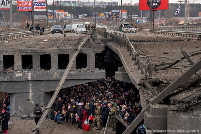 Oekraïners schuilen onder een vernielde brug wanneer ze proberen te vluchten over de Irpin rivier in de buitenwijken van Kiev, Oekraïne.