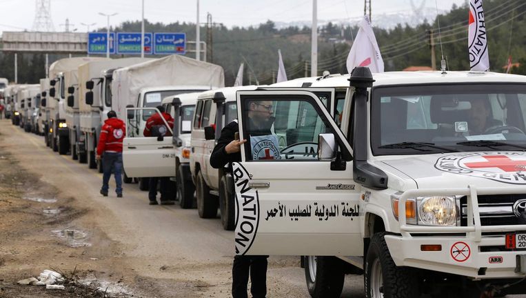 Wagens van het Syrische Rode Kruis wachten vlakbij Madaya. Beeld AFP