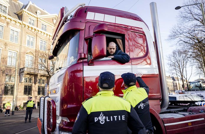 Politieagenten houden een vrachtwagen tegen die naar de ingang van het Binnenhof in Den Haag wil rijden tijdens een protestactie tegen de coronamaatregelen.