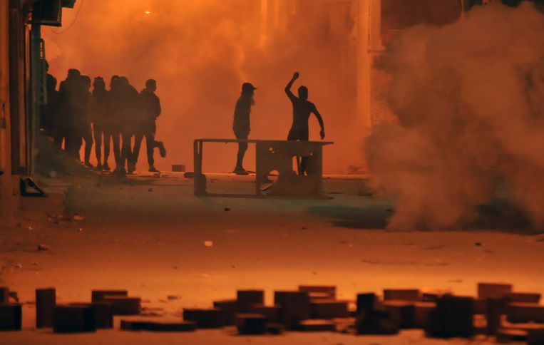 Tunesische betogers gooien met stenen naar veiligheidsagenten in de hoofdstad Tunis. Beeld AFP