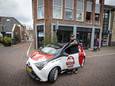 Medewerker van Chicken Express bij de bezorgauto.