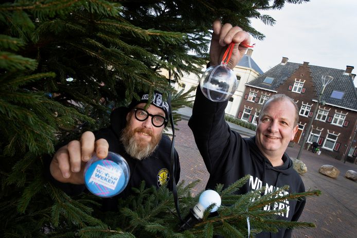 Sander Waterschoot van Wollige Winterweken en Richard Theuws van No Guts No Glory hangen een wensbal in de kerstboom in Geldrop.