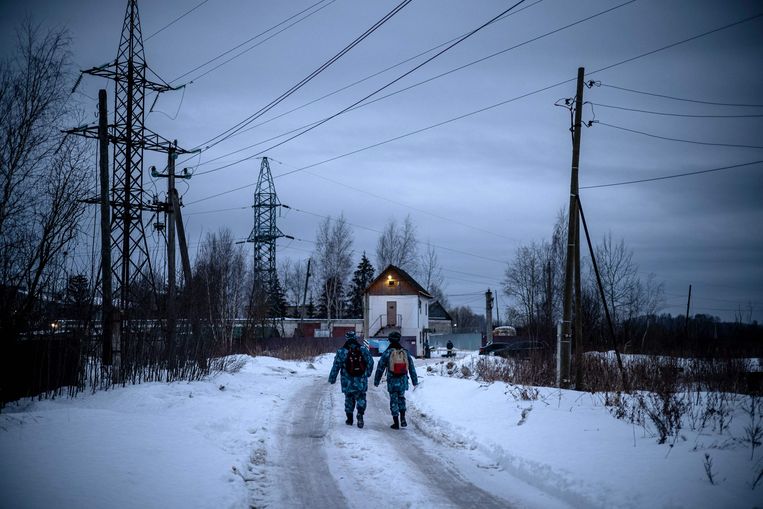 Twee bewakers van de Russische federale gevangenisdienst lopen richting de ingang van strafkolonie N2 in Pokrov, waar oppositieleider Aleksej Navalny een straf van 2,5 jaar uitzit. Beeld AFP