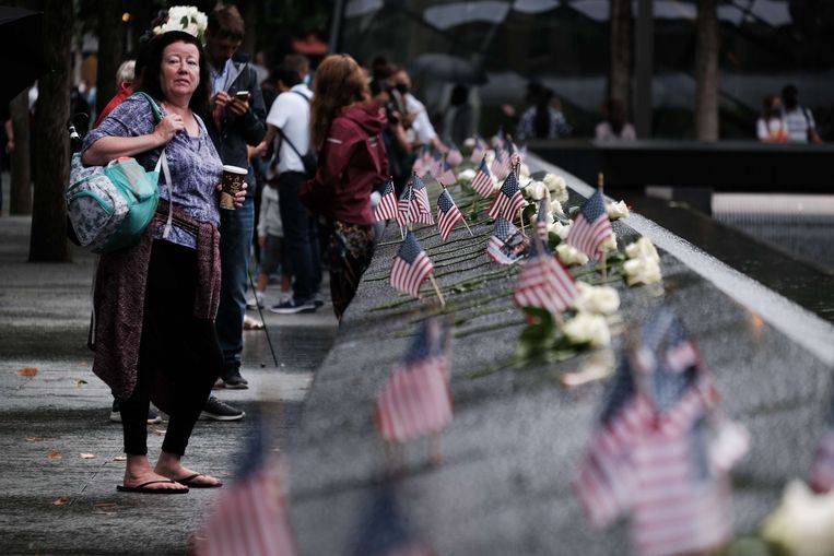 Mensen steken Amerikaanse vlaggetjes in het monument op Ground Zero in New York. Beeld AFP