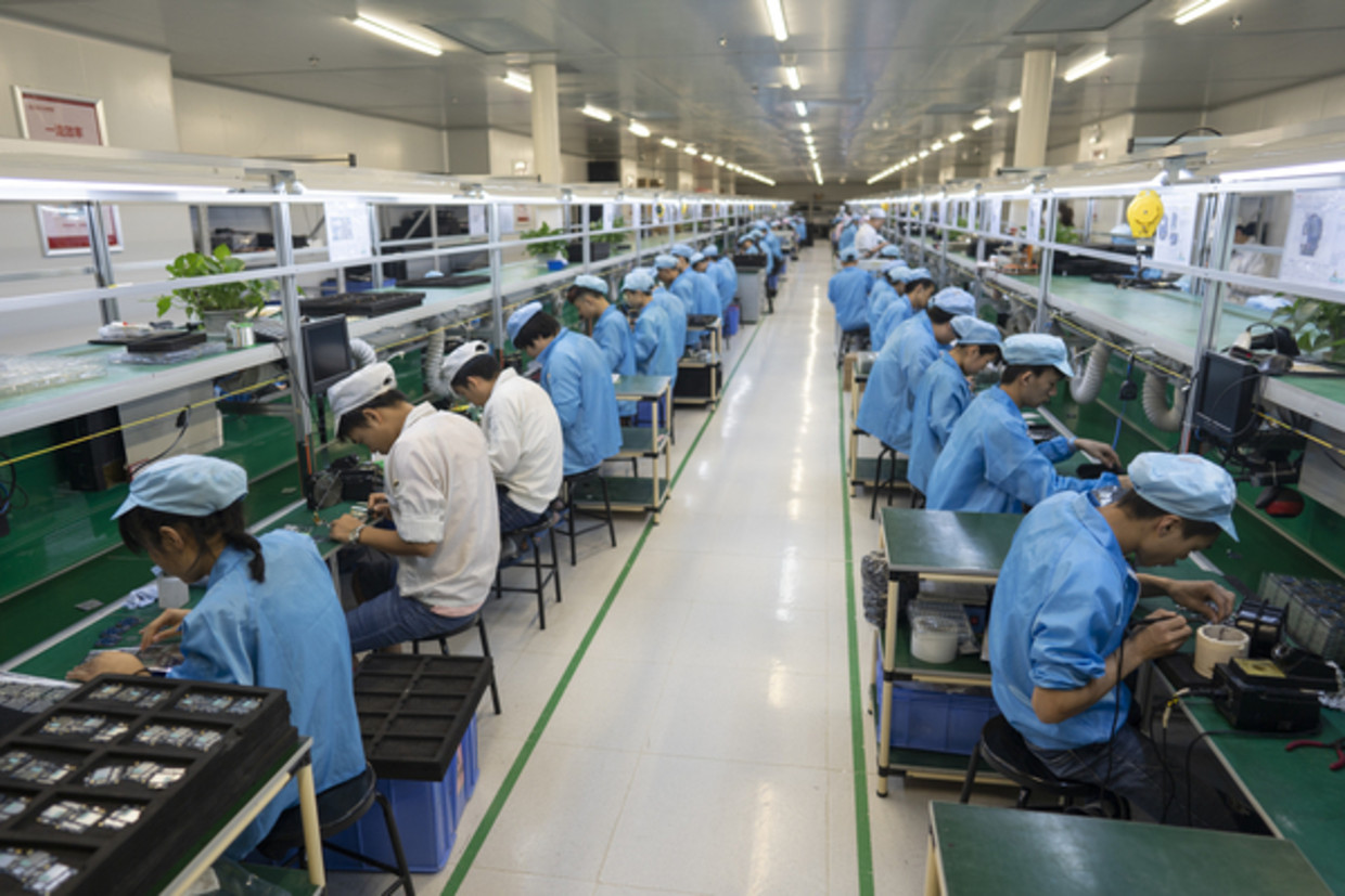 Productielijn voor consumentenelektronica bij Koomi Intelligent Technology in Shenzhenmi. Beeld Theodore Kaye