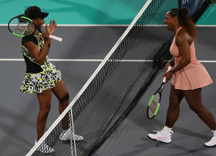 Venus (l) klopt haar jongere zus Serena in Abu Dhabi.
