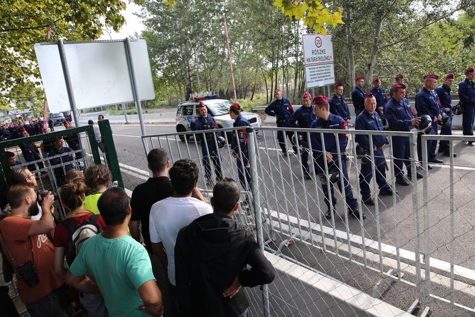 Vluchtelingen in september 2015 bij de grens tussen Servië en Hongarije. Hongarije liett ze niet door.
