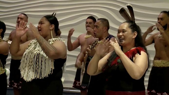 Maori's in traditionele kledij verwelkomen de reizigers bij aankomst op de luchthaven van Auckland met zang en dans.