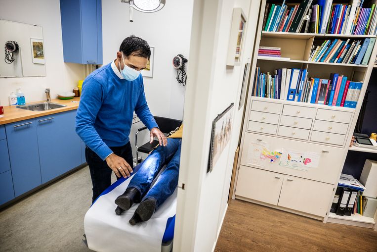 Huisarts Shakib Sana onderzoekt een patiënt in zijn praktijk in Rotterdam. Beeld Jiri Büller / de Volkskrant