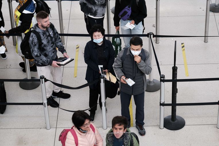 Mensen met en zonder mondkapjes op vliegveld JFK in New York, nadat een rechter in Florida de verplichting ongeldig verklaarde. Beeld AFP
