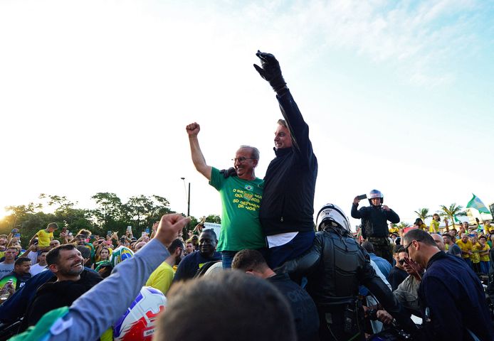 De huidige Braziliaanse president Jair Bolsonaro (rechts, met zwarte handschoenen) begroet zijn aanhangers in Joinville in de staat Santa Catarina, Brazilië.