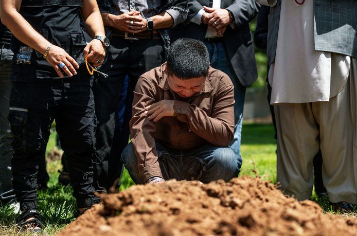 Altaf Hussain huilt bij het graf van zijn broer Aftab Hussein tijdens zijn begrafenis en die van Muhammad Afzaal Hussain op vrijdag 5 augustus.