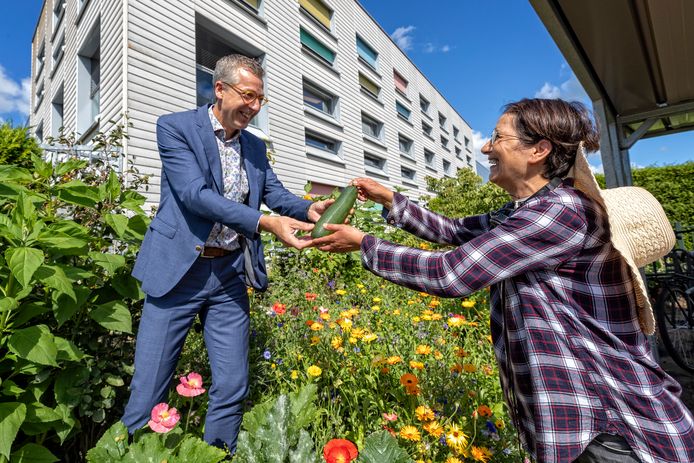 Scheidend directeur Jan de Vries van leerwerkbedrijf Rijnvicus krijgt van Sims Vasihzadeh als afscheidscadeau de eerste courgette uit de moestuin.