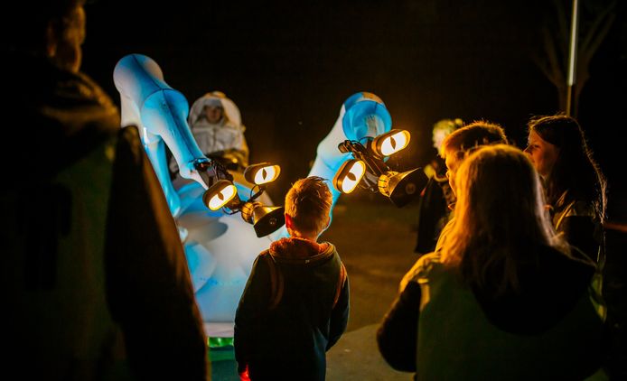 Kinderen bekijken een bijzonder lichtgevende installatie tijdens de theaterwandeltocht in Sint Jansklooster.