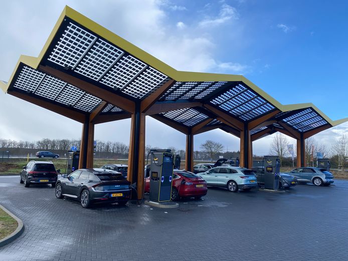 Nederlandse wintersporters laden hun elektrische auto's bij een Fastned-laadstation in Duitsland.