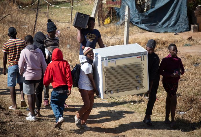 Relschoppers nemen hun plunderwaar mee in Soweto, in de buurt van Johannesburg.
