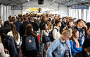 Wachtende reizigers bij een vertrekhal op luchthaven Schiphol.