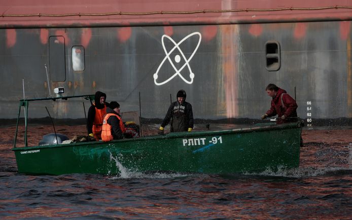 Een vissersbootje passeert de drijvende kerncentrale.