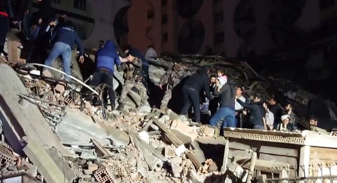 Reddingswerkers zoeken naar overlevenden tussen het puin van een ingestort gebouw in de Turkse stad Diyarbakir.