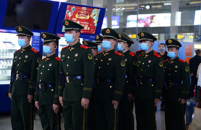 Militairen dragen maskers in een station in Shanghai.
