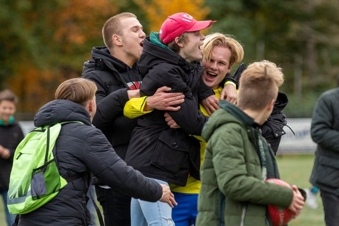 Matchwinnaar Rowan Mensink bedolven onder de jeugdige supporters van Hatto Heim na de Hattemse stadsderby.