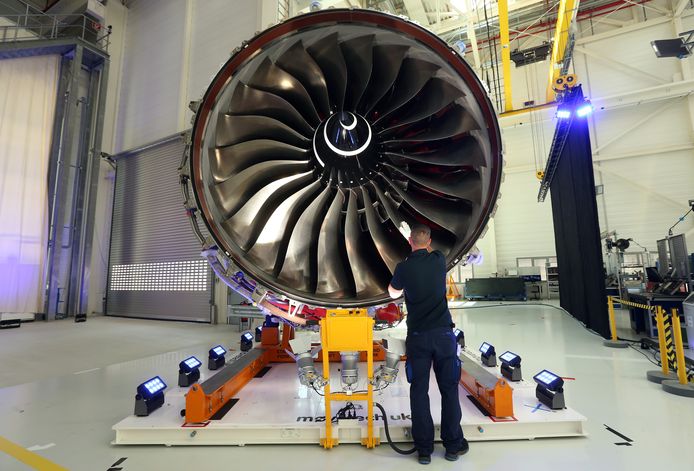 Een Rolls-Royce-medewerker inspecteert een vliegtuigmotor.
