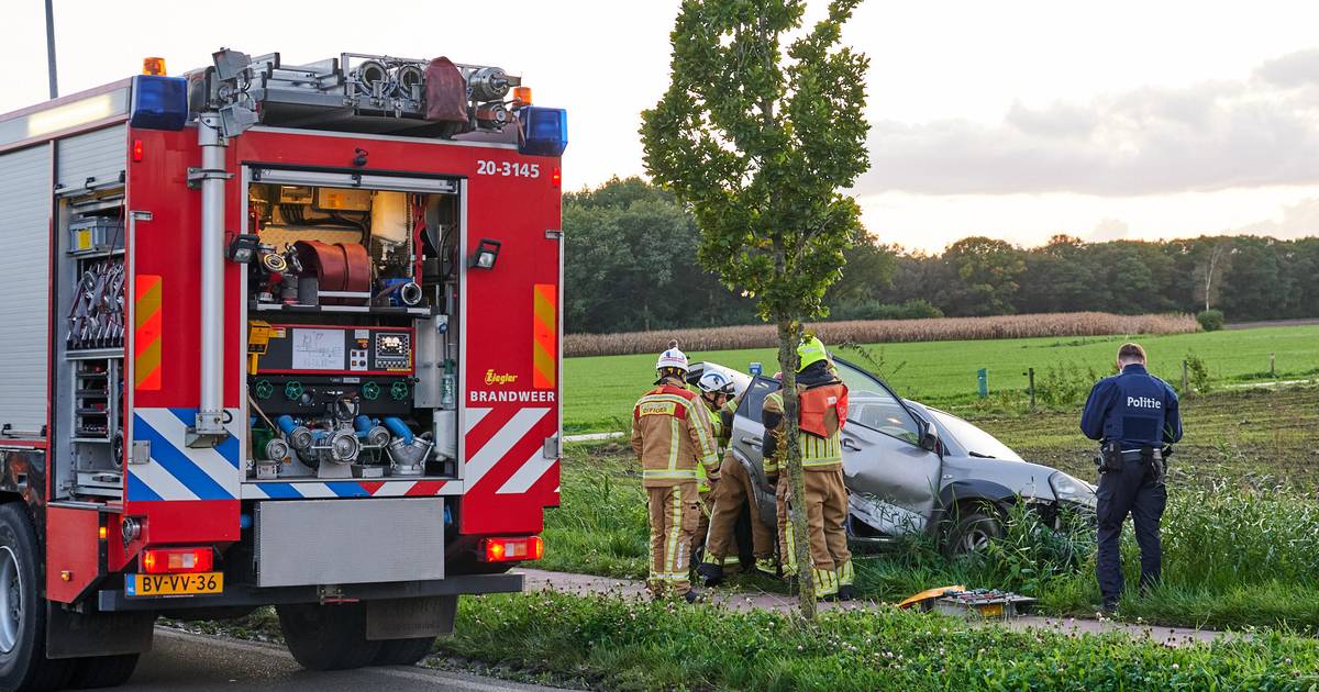 Nederlandse en Belgische brandweer halen gewonde uit auto in sloot, na ongeluk net over de grens.