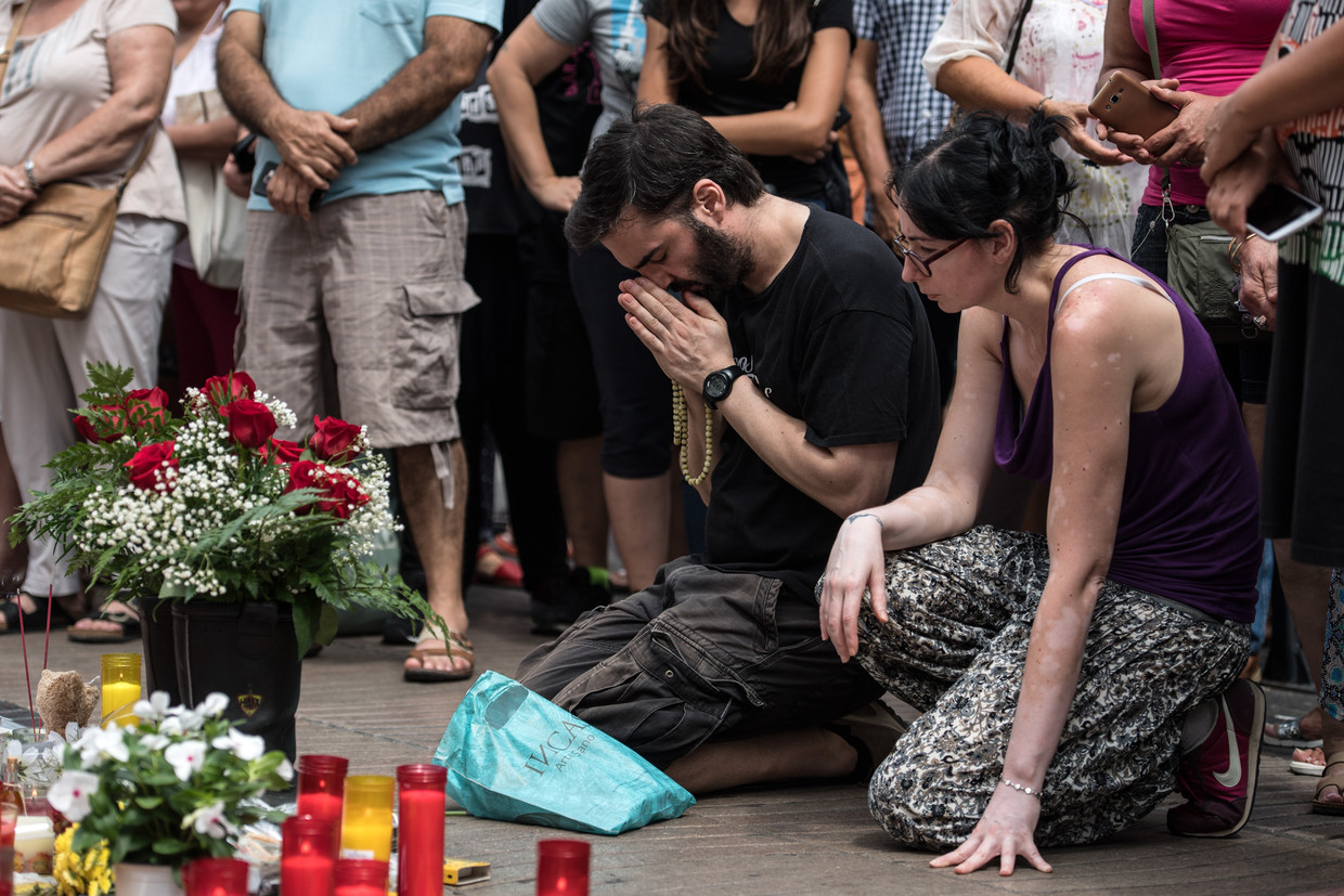 Rouwenden bij een plaats in Barcelona waar kaarsen en bloemen voor de slachtoffers van de aanslag zijn neergezet. Beeld Getty Images