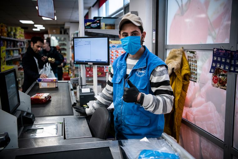 Een medewerker van een Turkse supermarkt in Groningen draagt een mondkapje en handschoenen. Niet zo zeer om zichzelf te beschermen tegen het coronavirus, maar omdat hij niet wil dat zijn klanten besmet raken. Beeld Kees van de Veen