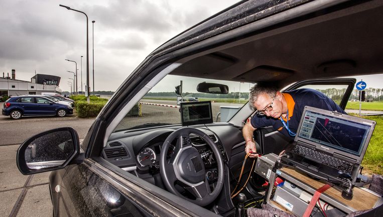 Inspecteur Harrie de Louweren installeert testapparatuur in een personenauto op het testcircuit van de RDW in Lelystad. Beeld Raymond Rutting