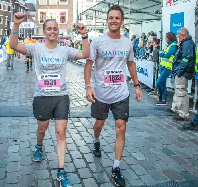 Esther ten Brinke en Rutger op den Dries komen juichend over de finish als ze de halve marathon in Zwolle hebben voltooid. Een uitvloeisel van de actie ‘Run for Dens’, waarmee zij hun aan acute leukemie lijdende broer een hart onder de riem wilden steken.